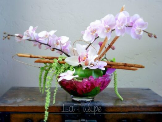 orchids in a bowl vase with bamboo