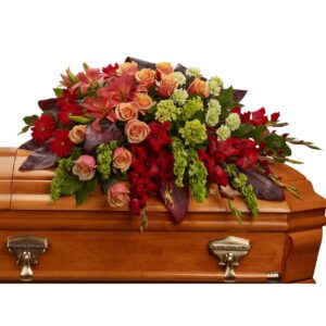 An overflowing of love and respect is joyfully expressed in this truly magnificent casket spray of orange roses and lilies and other brilliant blooms.