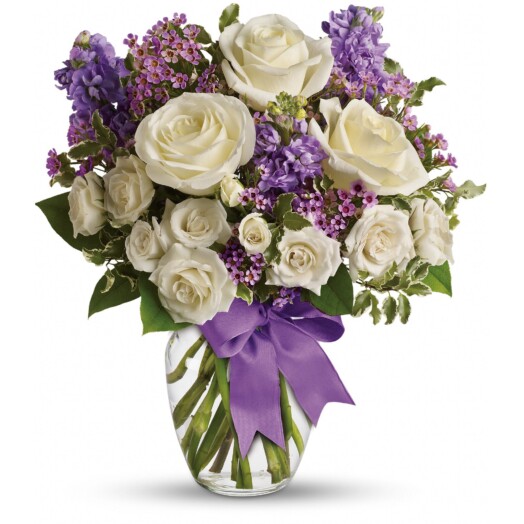 white roses with purple accents in glass vase