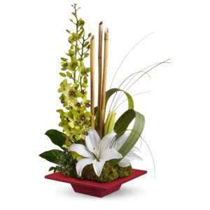 lilies and orchids in a flat vase