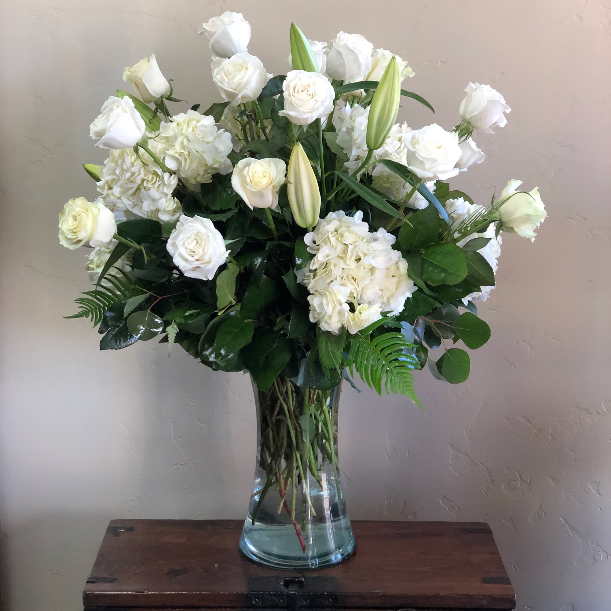 White flowers with greens in a vase